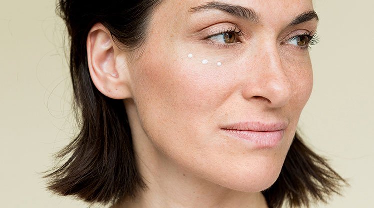 Frau mit aufgetragener Augencreme